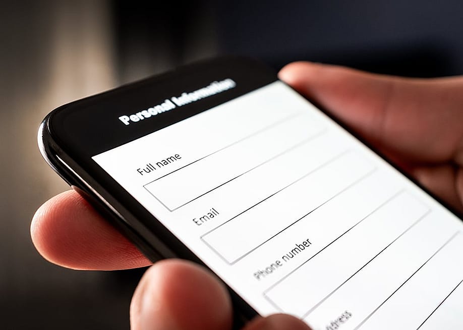 A user filling out the personal information part of an online survey using a smartphone. — Tero Vesalainen // Shutterstock