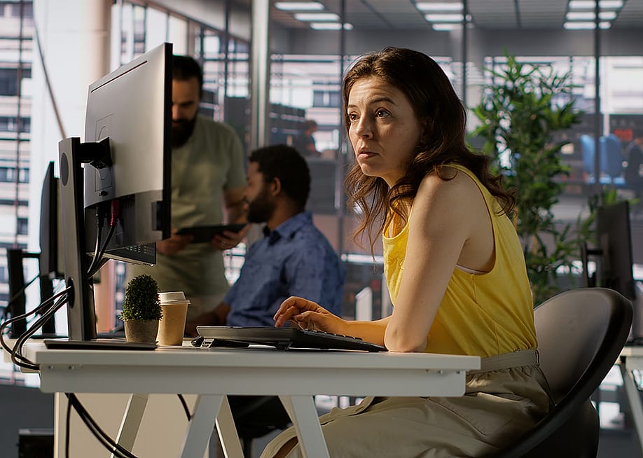 A female employee focused on a computer monitor while working in an office. — DC Studio // Shutterstock