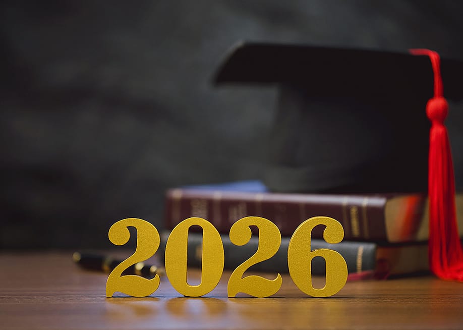 Golden '2026' numbers in front of a stack of books and a graduation cap. — chayanuphol // Shutterstock