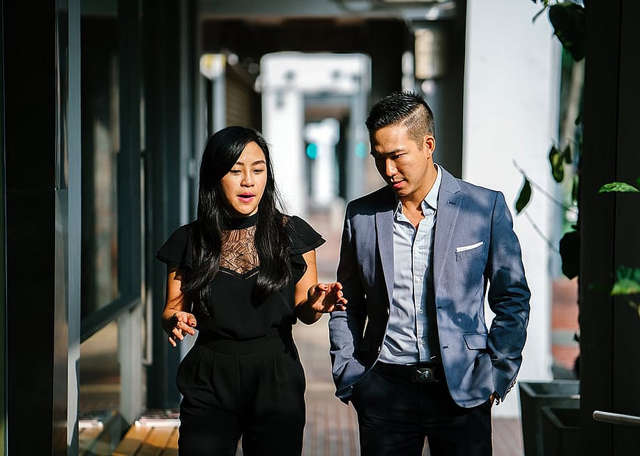 A pair of business people walking along a corridor. — mentatdgt // Shutterstock