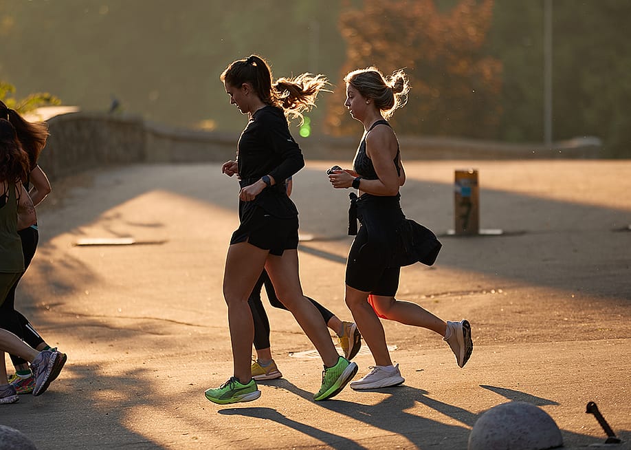 A group of women jogging outdoors. — hurricanehank // Shutterstock
