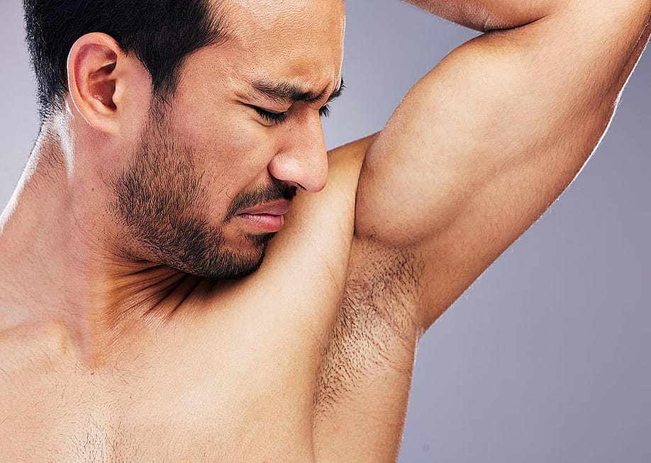 Man smelling his armpit. — PeopleImages // Shutterstock