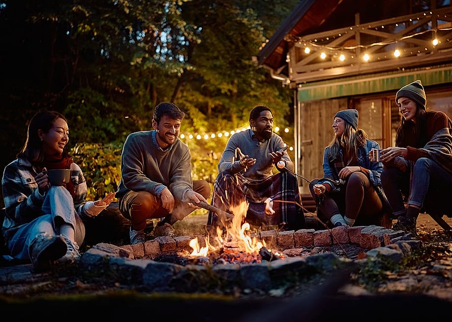 A group of friends around a campfire. — Drazen Zigic // Shutterstoc