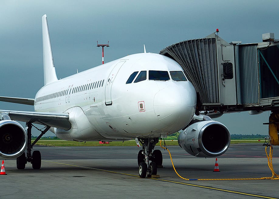 A charter airline airplane parked and connected to a boarding bridge. — josefkubes // Shutterstock