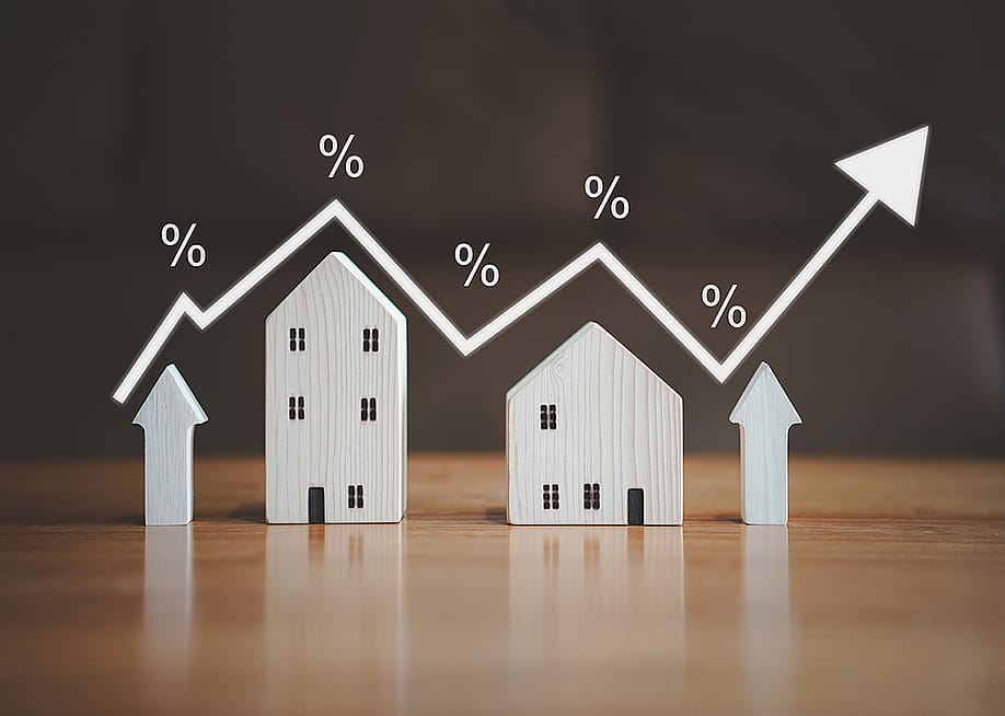 Small figures of houses and upward arrows illustrated with an increasing arrow and percentage rate graphics. — OMG_Studio // Shutterstock