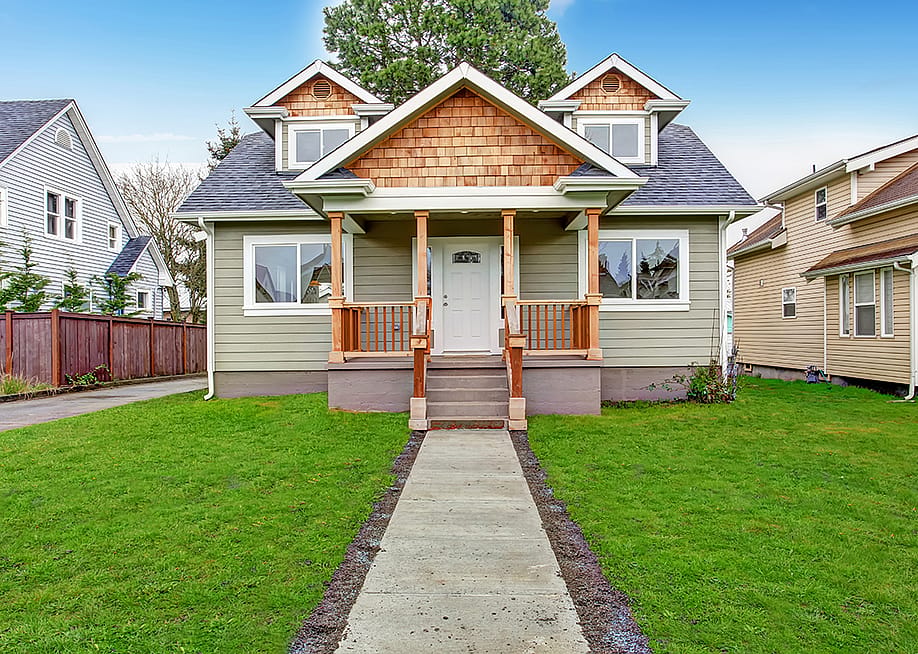 View of a walkway leading to a small house with a porch. — Artazum // Shutterstock