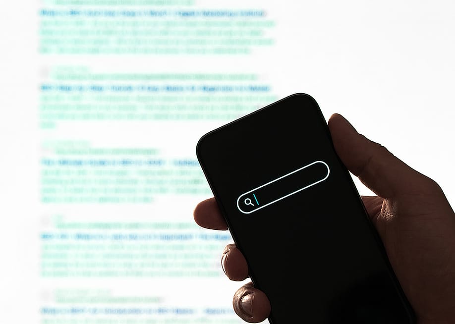 Search engine display on phone, against a background of paragraphs of information. — Tero Vesalainen // Shutterstock