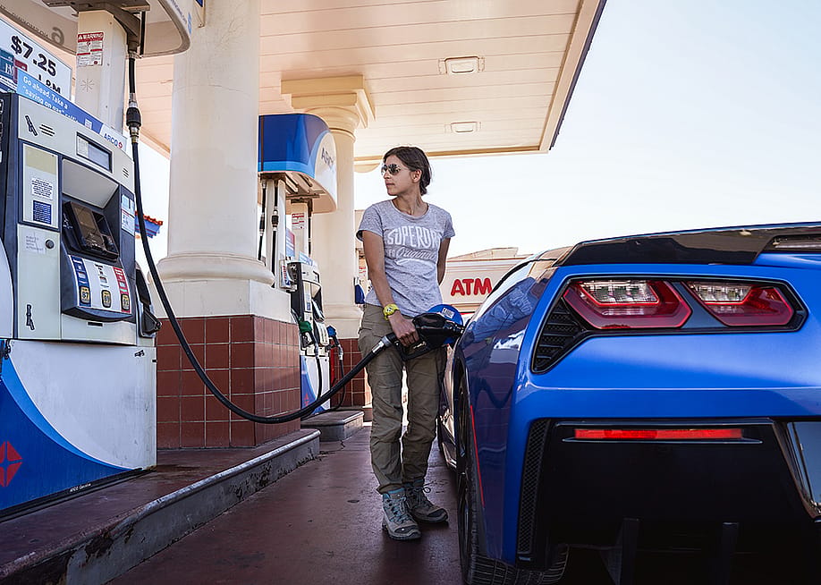 A woman refueling a Corvette car. — WildSnap // Shutterstock