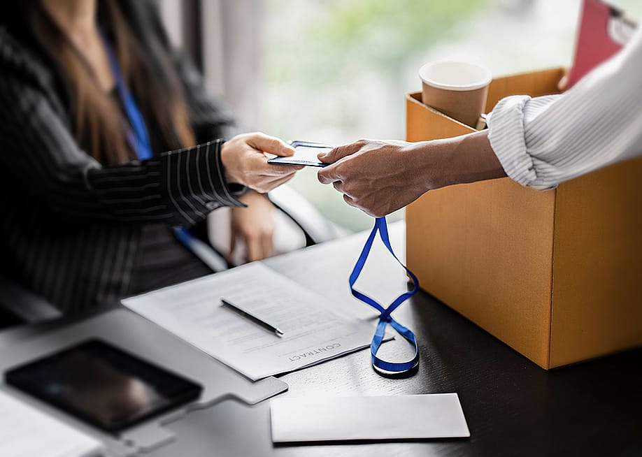 Employee handing in company ID during resignation. — mojo cp // Shutterstock