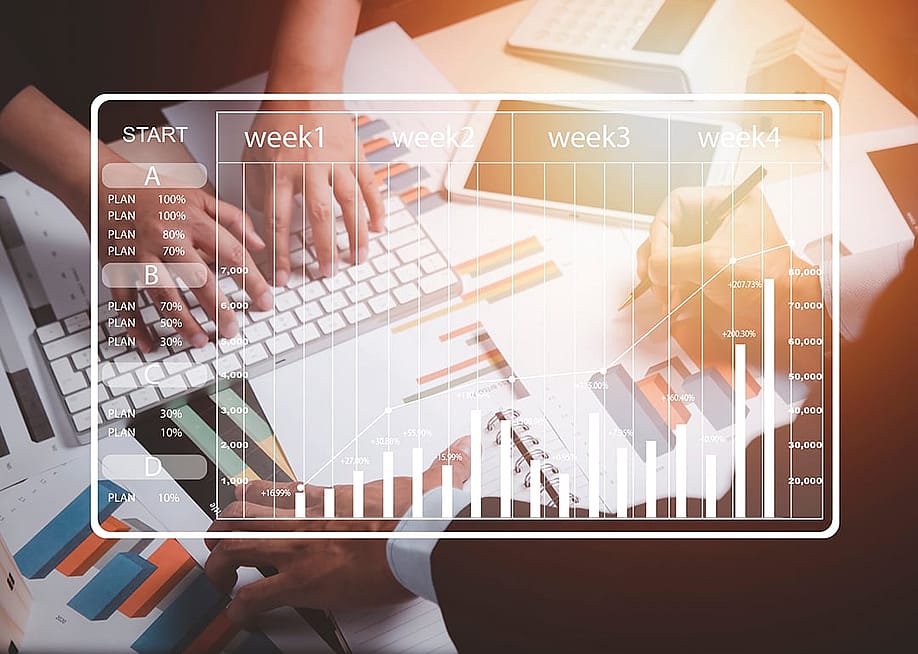 A business team working on charts and reports illustrated with a weekly calendar graphic. — Tapati Rinchumrus // Shutterstock