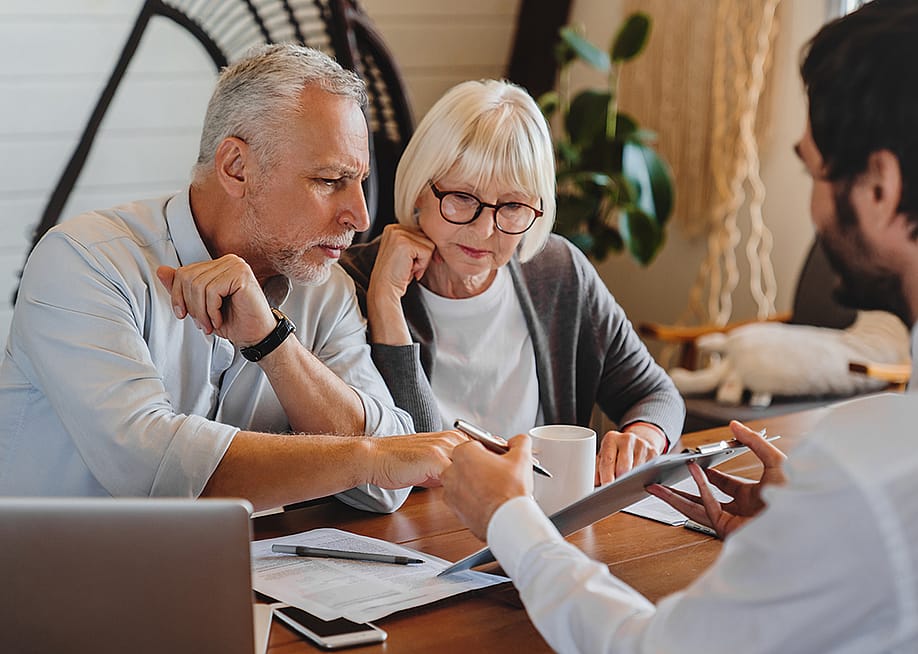 A senior couple consulting with a real estate professional. — Inside Creative House // Shutterstock