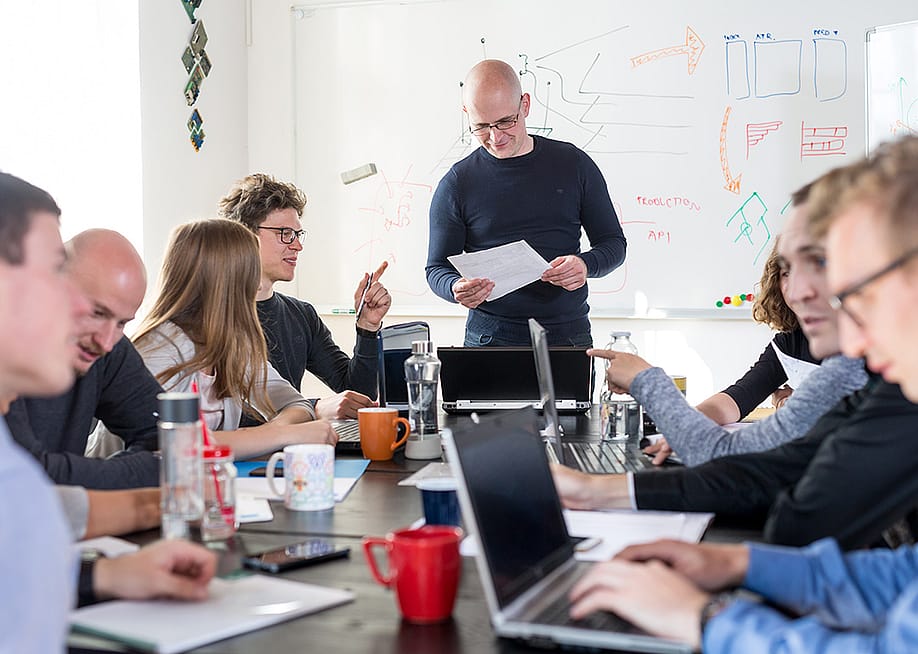 A business team brainstorming in a meeting room. — Matej Kastelic // Shutterstock