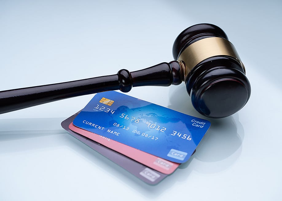 A gavel and a few credit cards laid on a table. — Andrey_Popov // Shutterstock