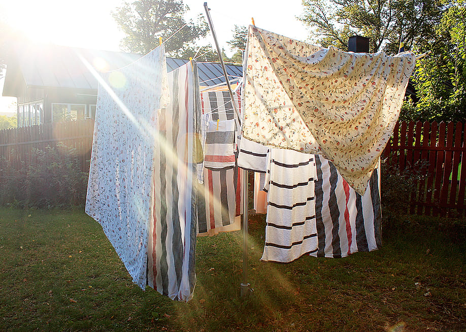 Washed sheets hanging from clothesline to dry under the sun. — Parrot Ivan // Shutterstock