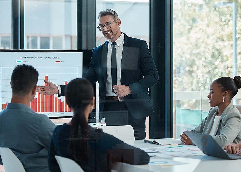 A CEO leading a business presentation in a boardroom. — PeopleImages // Shutterstock