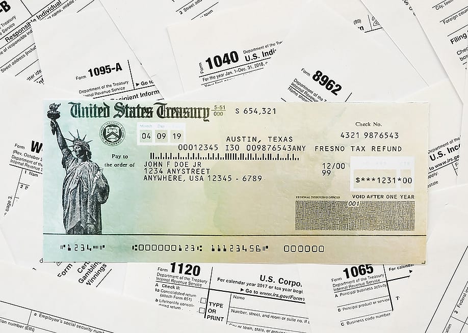 A US Treasury refund check on top of tax forms. — Mehaniq // Shutterstock
