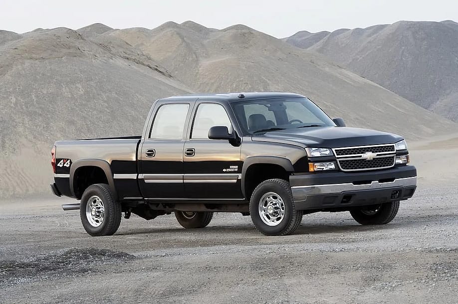 2006–2007 Black Chevrolet Silverado/GMC Sierra 2500HD/3500HD (6.6-liter Duramax LBZ) parked on rocky sand. — RealTruck.com