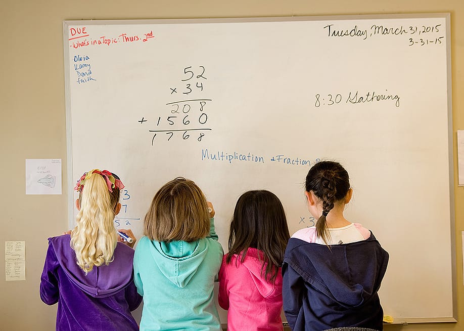 A group of children working to solve math problems on a whiteboard. — Mindy Schauer // Digital First Media / Orange County Register via Getty Images