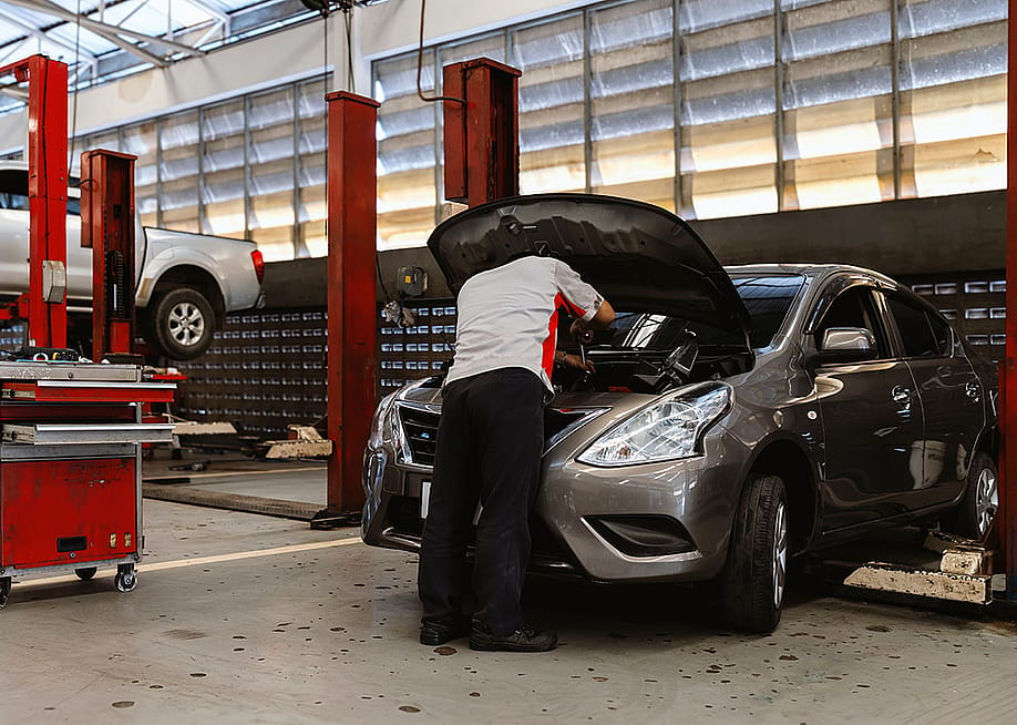 A car technician working on maintenance of a car engine. — Memory Stockphoto // Shutterstock