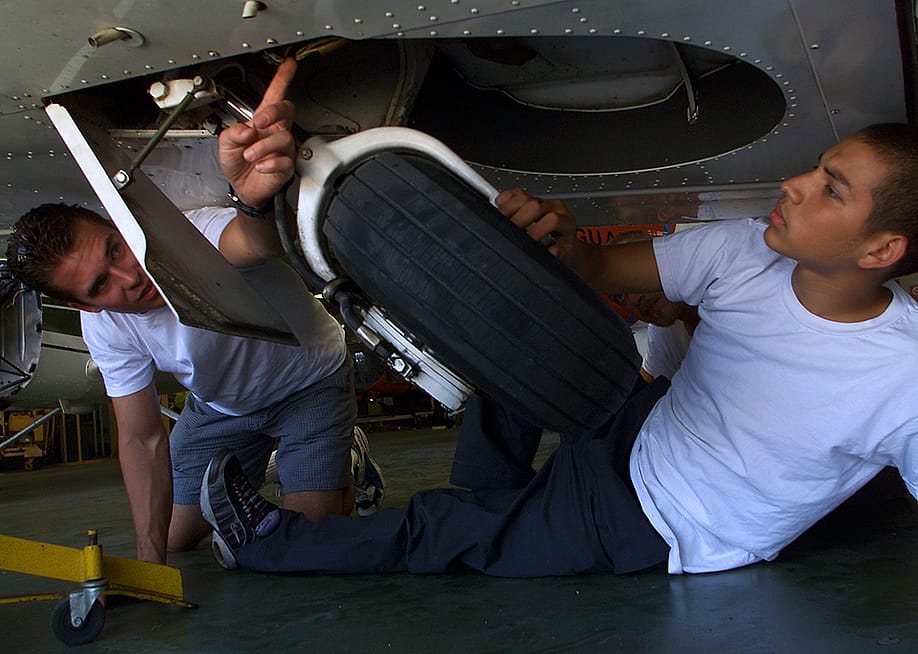 Aircraft mechanic students inspect a jet's landing gear. — George Wilhelm // Los Angeles Times via Getty Images
