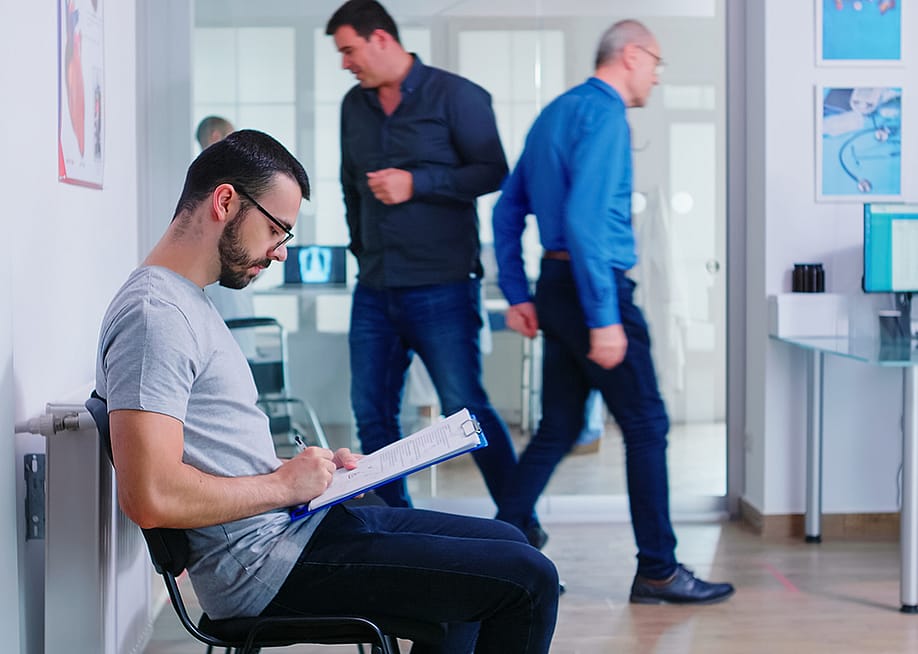 A person filing a document in a hospital waiting area. — DC Studio // Shutterstock