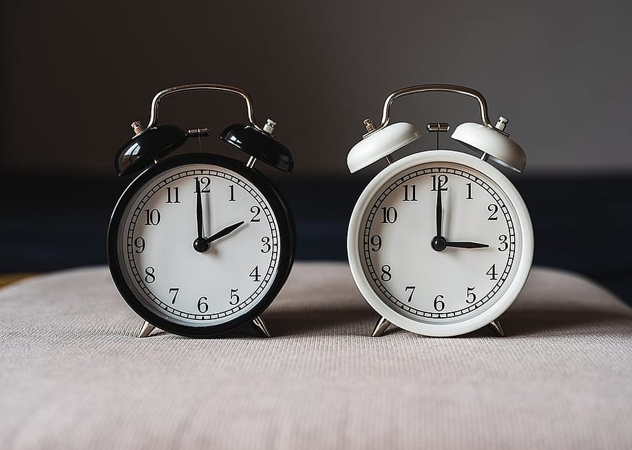 Two retro table clocks representing daylight savings time. — Robert Petrovic // Shutterstock