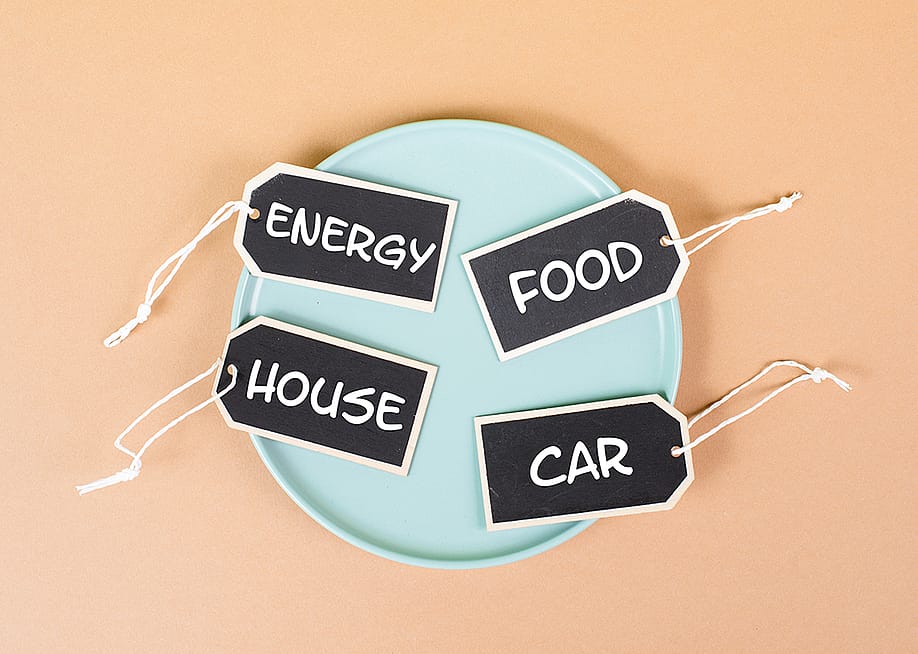 High living expenses labeled on tags in a plate. — Berit Kessler // Shutterstock