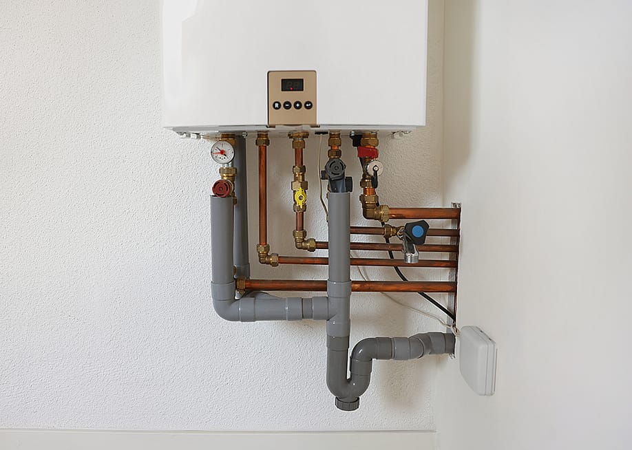 A modern gas boiler on a white wall. — New Africa // Shutterstock