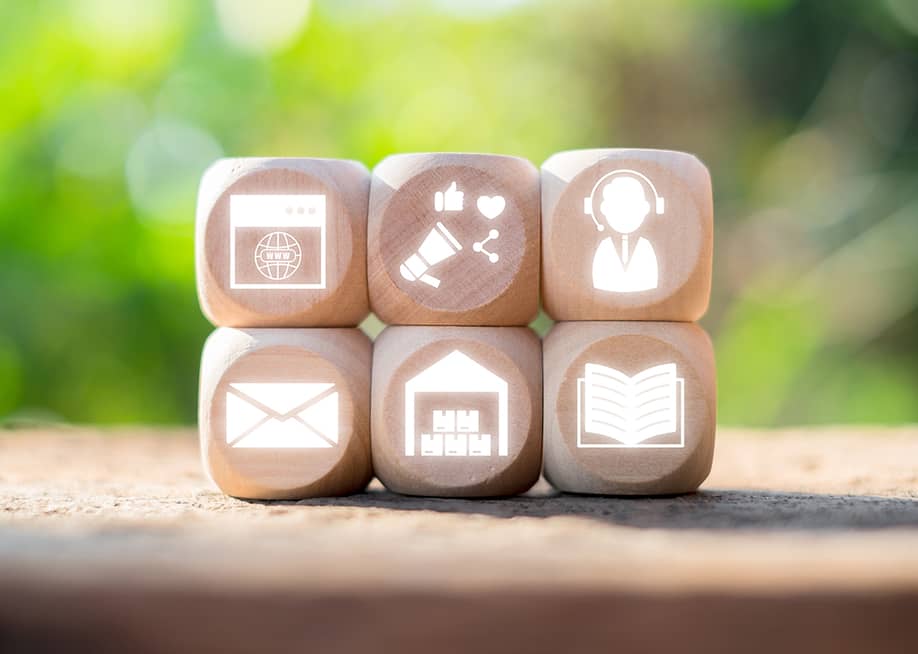 Wooden blocks with icons representing omni channel marketing and communication concepts. — Mongta Studio // Shutterstock