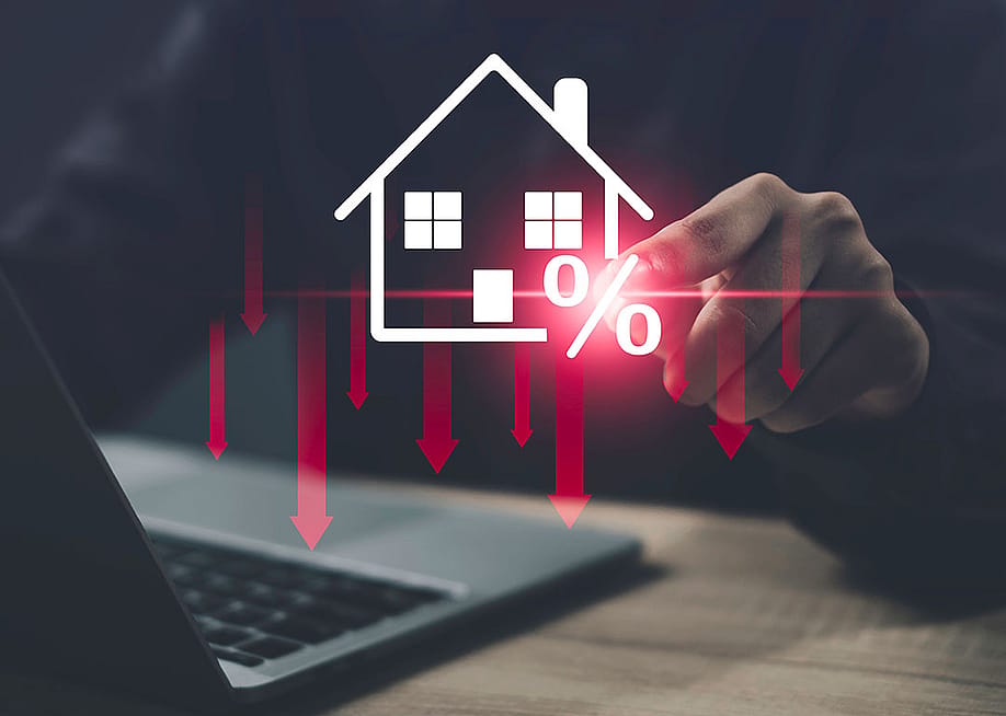 Person using a laptop illustrated with graphics showing concept of lower costs of housing. — Fah Studio 27 // Shutterstock