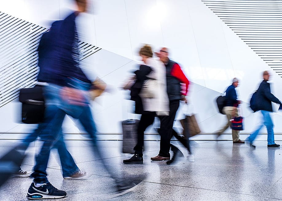 A motion blur shot of passengers walking inside an airport. — Netfalls Remy Musser // Shutterstock