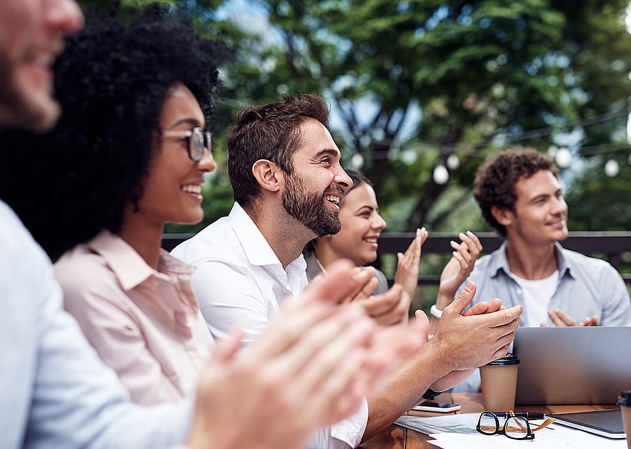 Colleagues applauding during a corporate retreat session. — PeopleImages // Shutterstock
