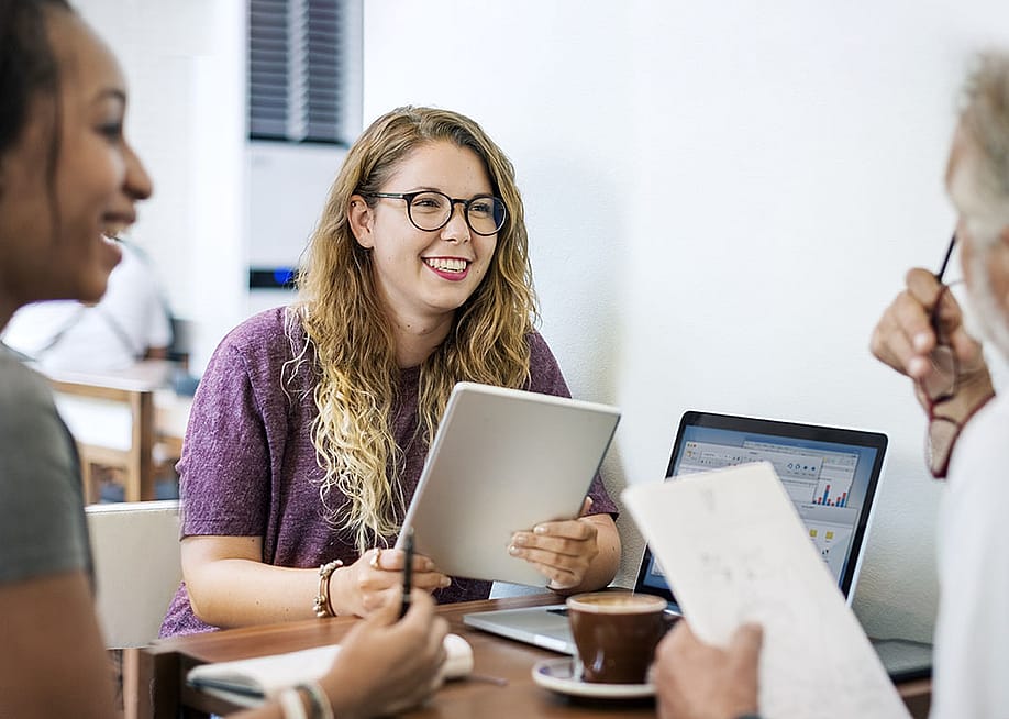 Young colleagues engaged in a discussion with a senior professional. — Rawpixel.com // Shutterstock