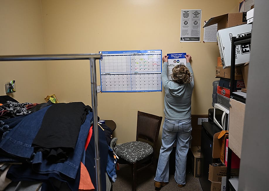 Denver Labor and Auditor's Office staff hangs a poster about wage changes. — RJ Sangosti // MediaNews Group / The Denver Post via Getty Images