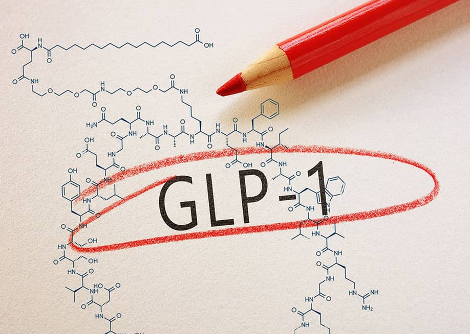 ‘GLP-1’ text emphasized on paper, with a chemical structure in the background. — zimmytws // Shutterstock