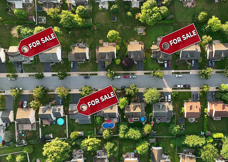 A top aerial view of a neighborhood with some homes marked ‘For Sale.’ — TechAnimationStock // Shutterstock