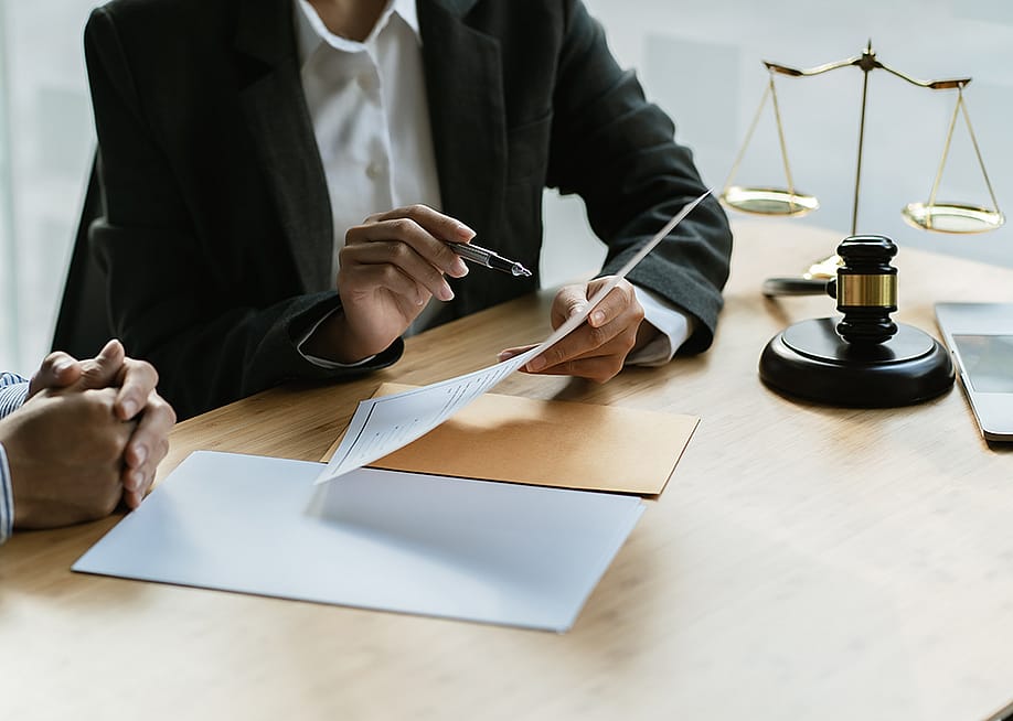 A legal counsel presenting a contract to a client in a law office. — PaeGAG // Shutterstock