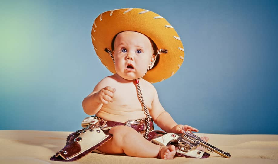 960s Baby Boy With Surprised Facial Expression Dressed As Cowboy Wearing Hat And Holster And Gun — H. Armstrong Roberts/Classicstock // Getty Images