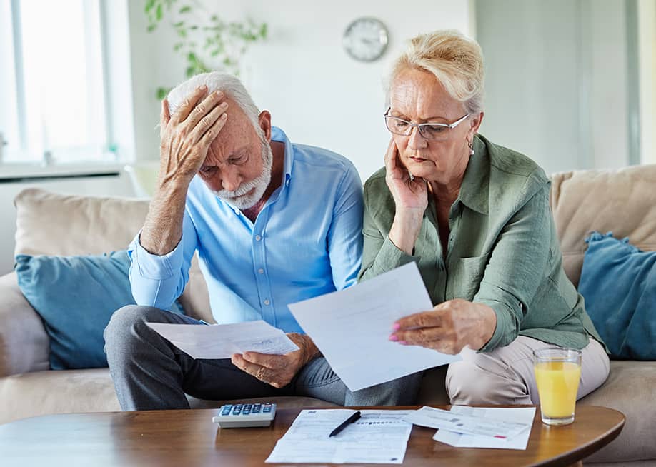 An elderly couple checking bills at home. — pics five // Shutterstock