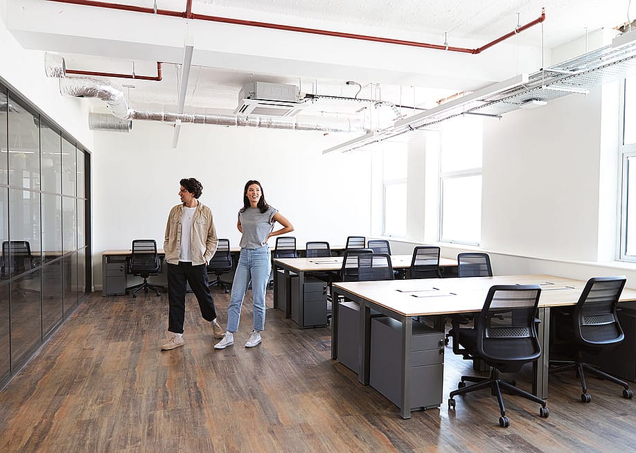 Colleagues looking around an empty modern office for startup plans. — Southworks // Shutterstock