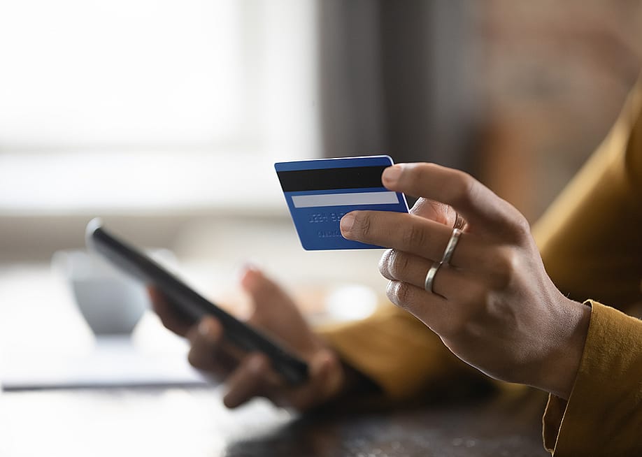 Female customer using a credit card and checking a phone. — fizkes // Shutterstock