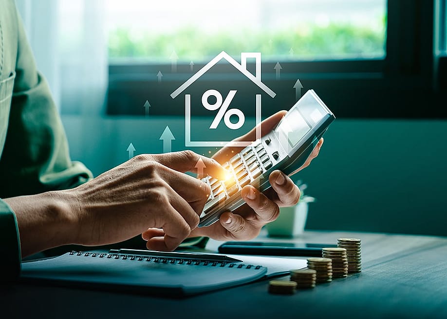 Person using a calculator illustrated with increasing mortgage rate concep graphics. — Sutthiphong Chandaeng // Shutterstock