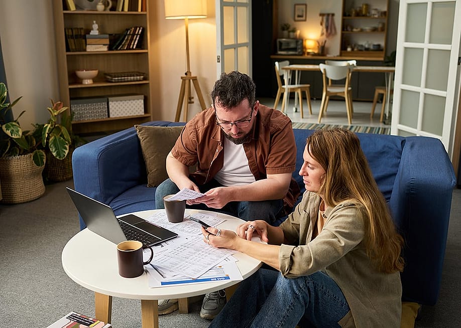 Two people reviewing expenses and financial documents for tax filing. — Pressmaster // Shutterstock