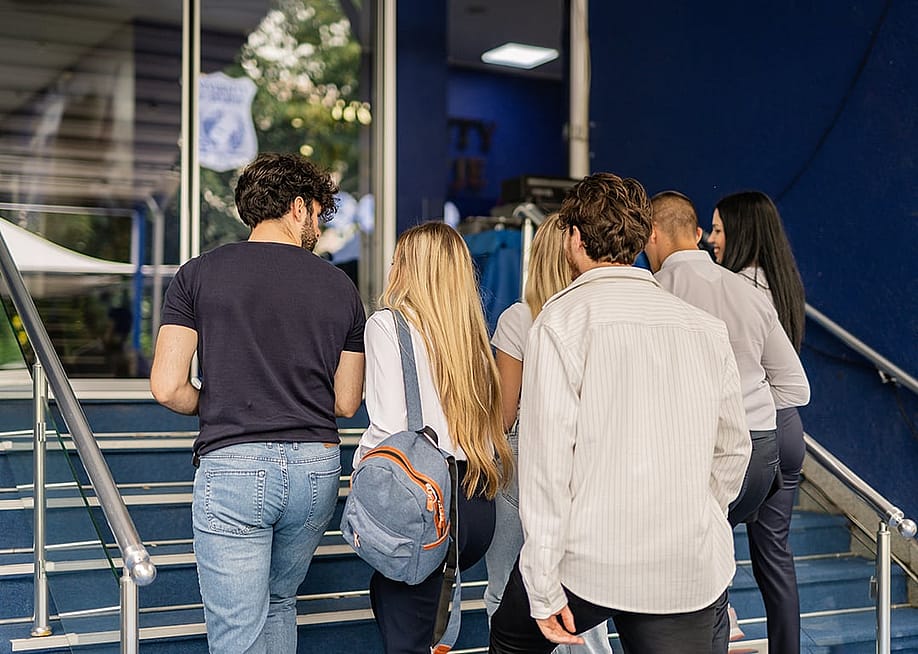 Five college students walking upstairs for a class. — Gorgev // Shutterstock