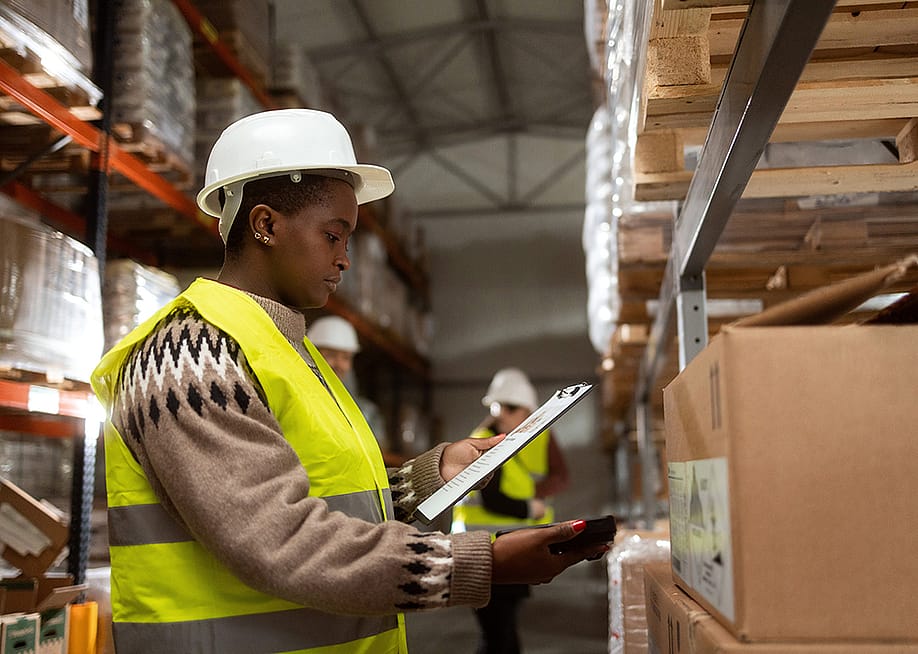 A worker doing a package inventory in a distribution warehouse. — Stock Rocket // Shutterstock