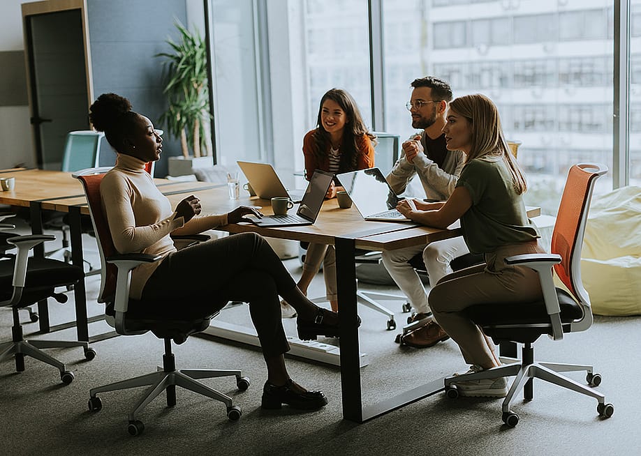 An employee sharing ideas to teammates in a workplace meeting. — BGStock72 // Shutterstock