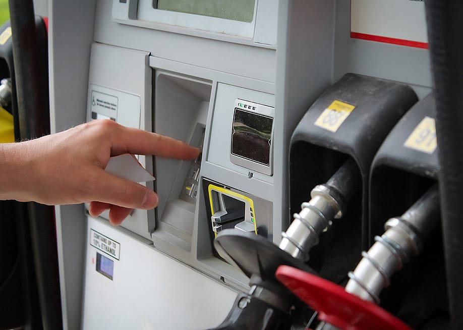 Person entering numbers on a fuel pump station keypad. — mailcaroline // Shutterstock