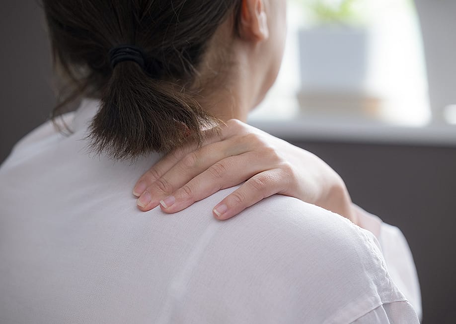 Woman suffering from stiff shoulders. — kapinon.stuio // Shutterstock