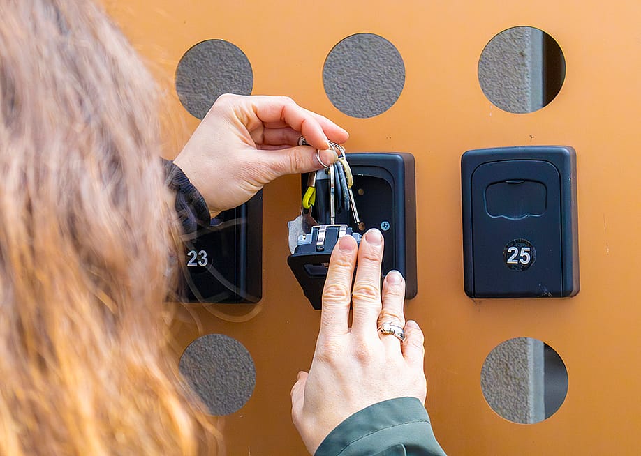 A person putting keys inside an apartment key box. — JairoMZ // Shutterstock