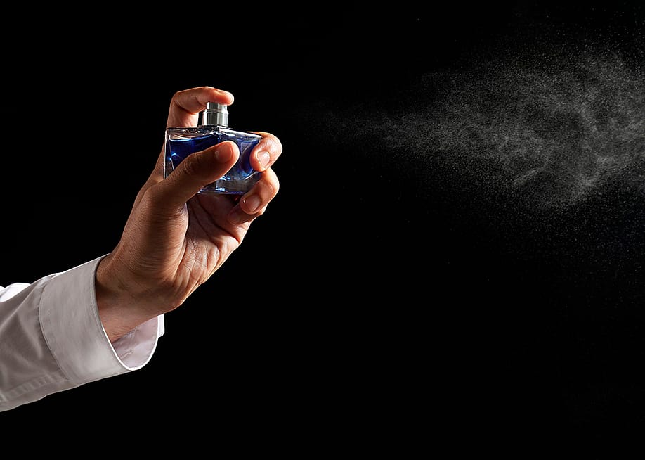 Luxury perfume being sprayed in the air. — New Africa // Shutterstock